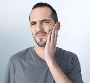 'man holding pain with jaw surgery'
